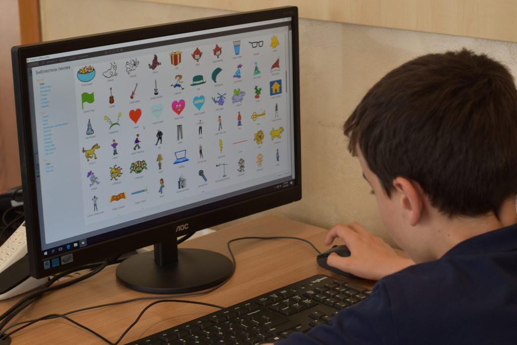 Dete bira lik iz Scratch biblioteke na ekranu