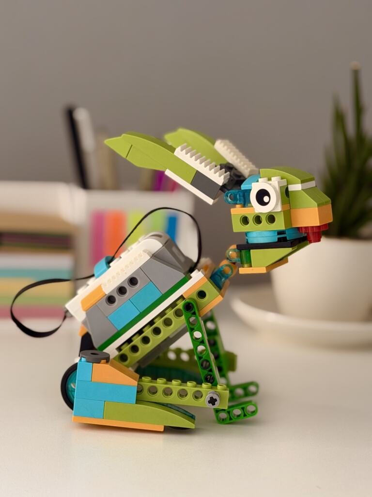 Sklopljen LEGO WeDo zec na stolu u učionici, oko njega razbacane kocke